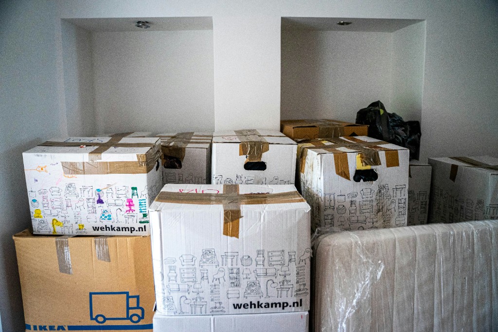 Packed moving boxes and wrapped furniture ready for transport